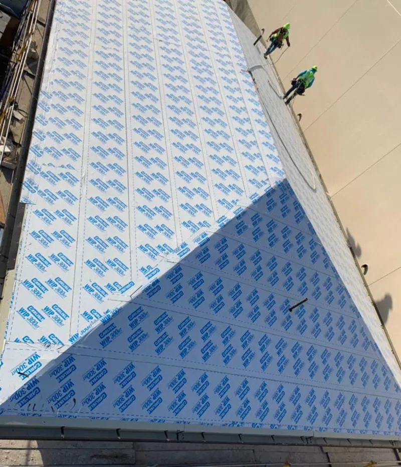 Professional roofers installing underlayment on a metal roof in East Hanover